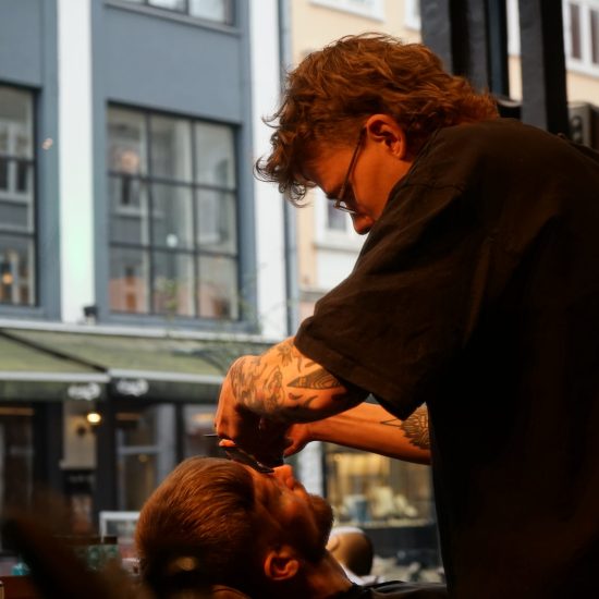 Barber klipper hår i barbershop